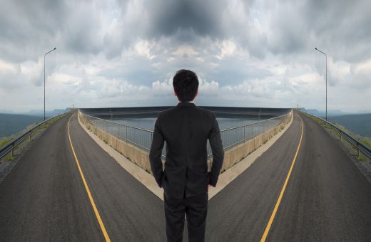 A man standing in the middle of two roads