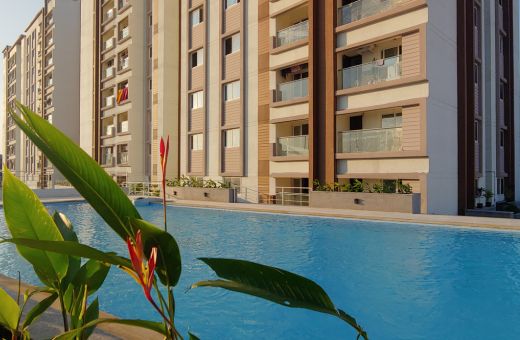 Spectacular view of DRA Homes' 2, 3 and 4 BHK Flats in Velachery, Chennai. A stunning swimming pool is on the foreground.