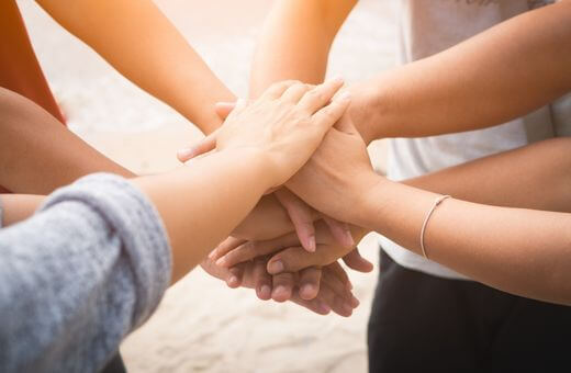 Group of people placing hands together and showing the bond among them