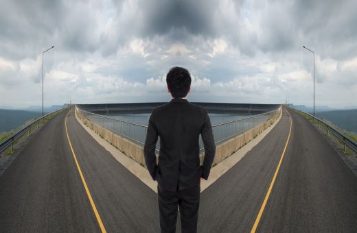  A man standing in the middle of two roads