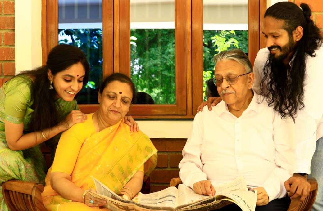 A happy family of four is reading a newspaper and looking to buy a home in Chennai for whatever reasons they have