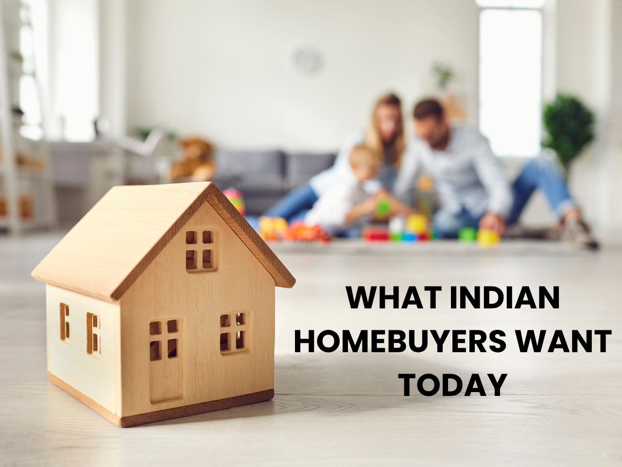 Indian couple playing with child in modern apartment, with a wooden house model in focus, symbolising first-time homebuyers, lifestyle upgrades, and evolving homeownership trends in India.
